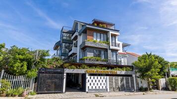 A modern multi-story building with a sign reading "Charm Champion Villa."