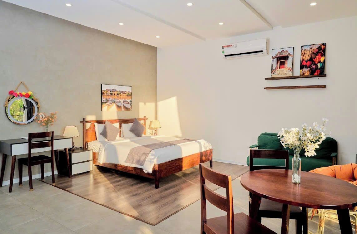 A modern bedroom with a wooden bed, a desk, and a dining area.