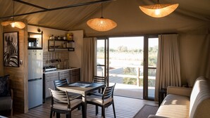 A spacious kitchen with a dining area, large windows, and a view of the outdoors.