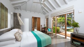 A modern bedroom with a bed, a ceiling fan, a dining area, and a view of the outdoors. - Kirana - A Santani Villa (Bentota)