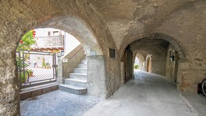 A stone corridor with arches, a staircase, and a gate. - Casa Gio Near the Waterfall Varone (Riva del Garda)