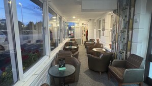 A modern lounge area with seating and a view of the street.