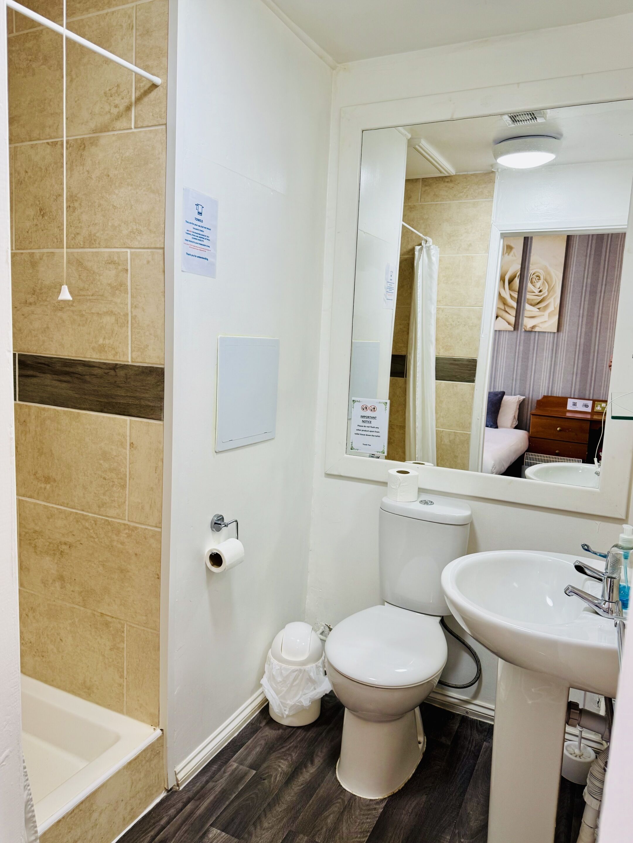 A bathroom with a toilet, sink, and shower area.