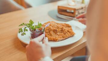 Un tavolo da pranzo con un piatto di cibo, un vasetto di salsa e una piccola pianta.