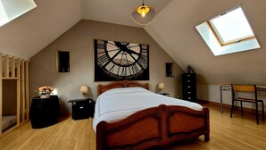 A bedroom with a wooden bed, a large clock on the wall, a skylight, and a desk with a chair. - Character house from 1894 in the heart of the Champagne vineyards, near Epernay (Avize)