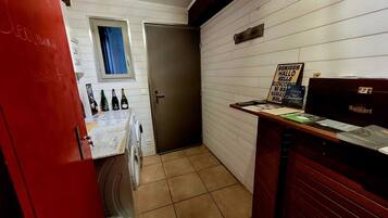 Un couloir étroit avec une porte, une petite fenêtre et un comptoir d’accueil avec une enseigne.