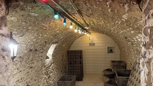 An underground room with stone walls, wooden benches, and a door. - Character house from 1894 in the heart of the Champagne vineyards, near Epernay (Avize)