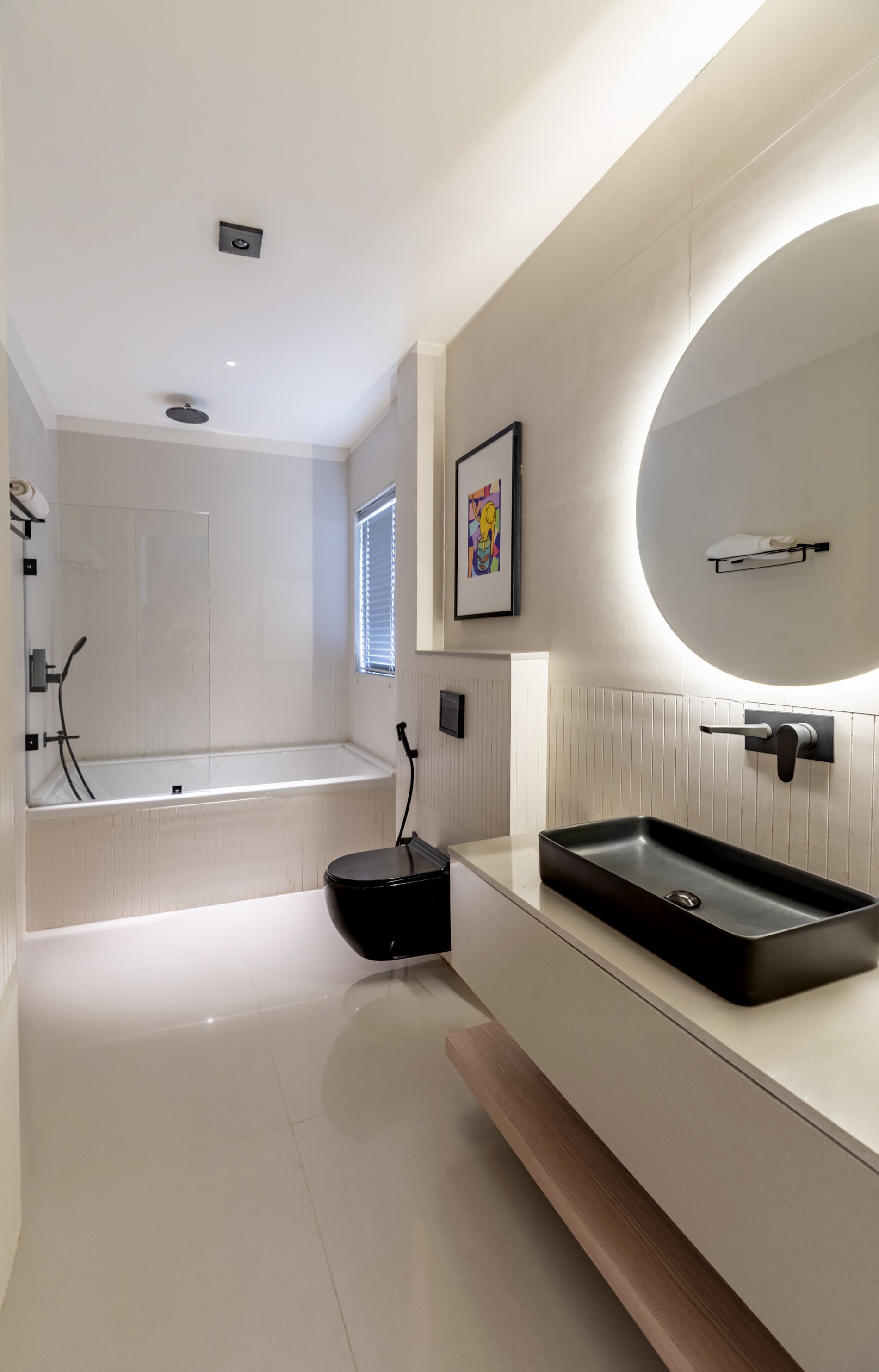 Een moderne badkamer met een bad, toilet en wastafel.