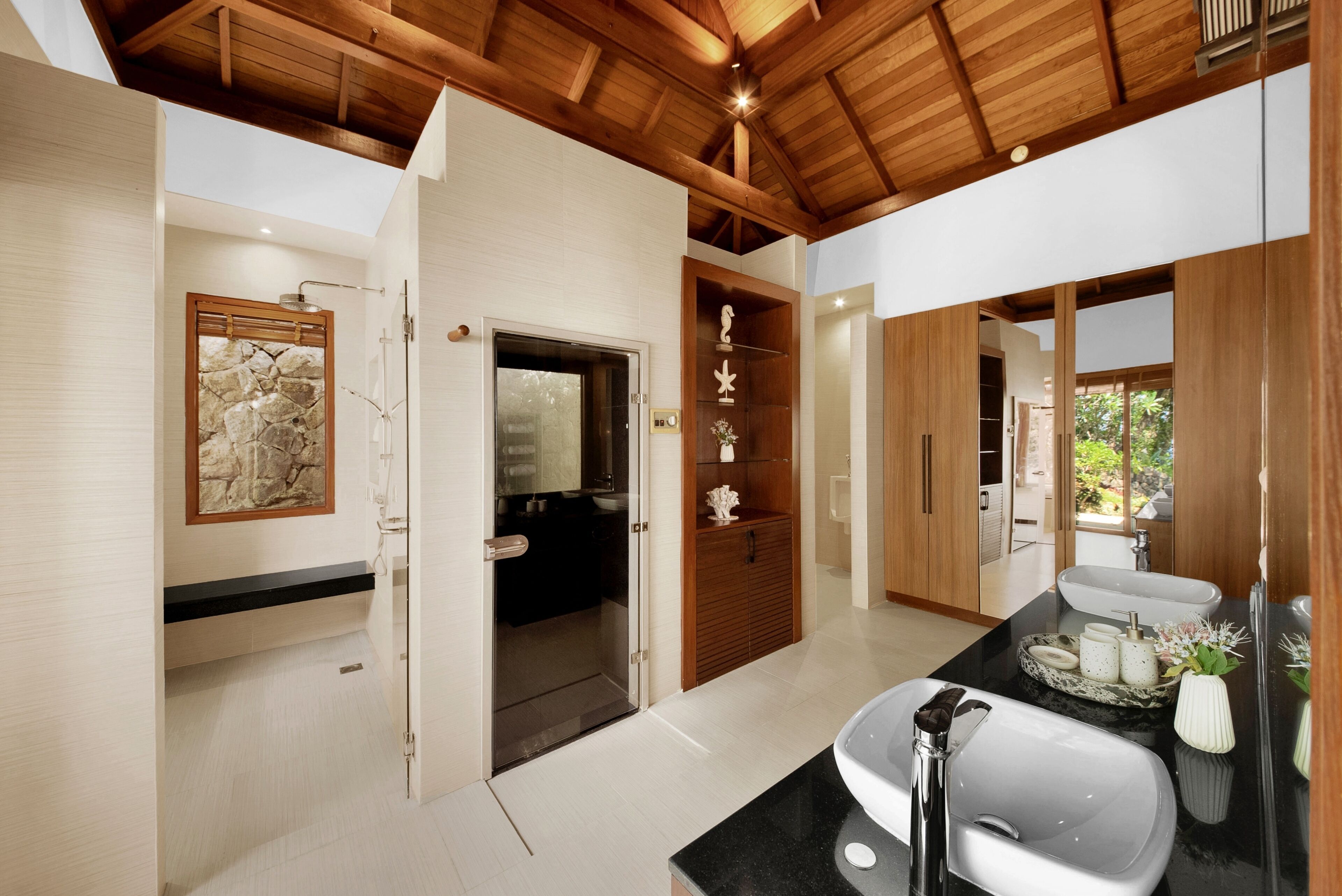 A modern bathroom with a black countertop, white sink, and a wooden ceiling.