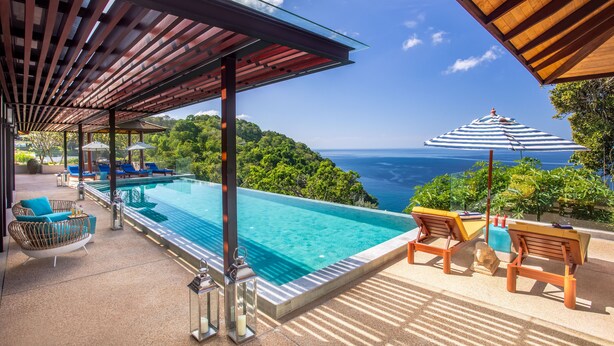 A poolside area with a view of the ocean, lounge chairs, and umbrellas. - Villa Varya (Kamala)