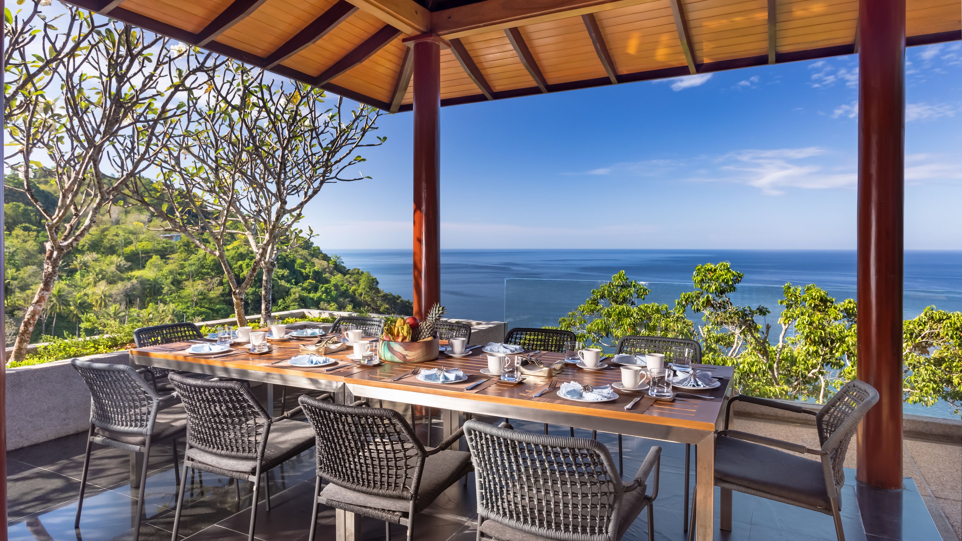 Une table dressée pour le dîner, avec vue sur l’océan.