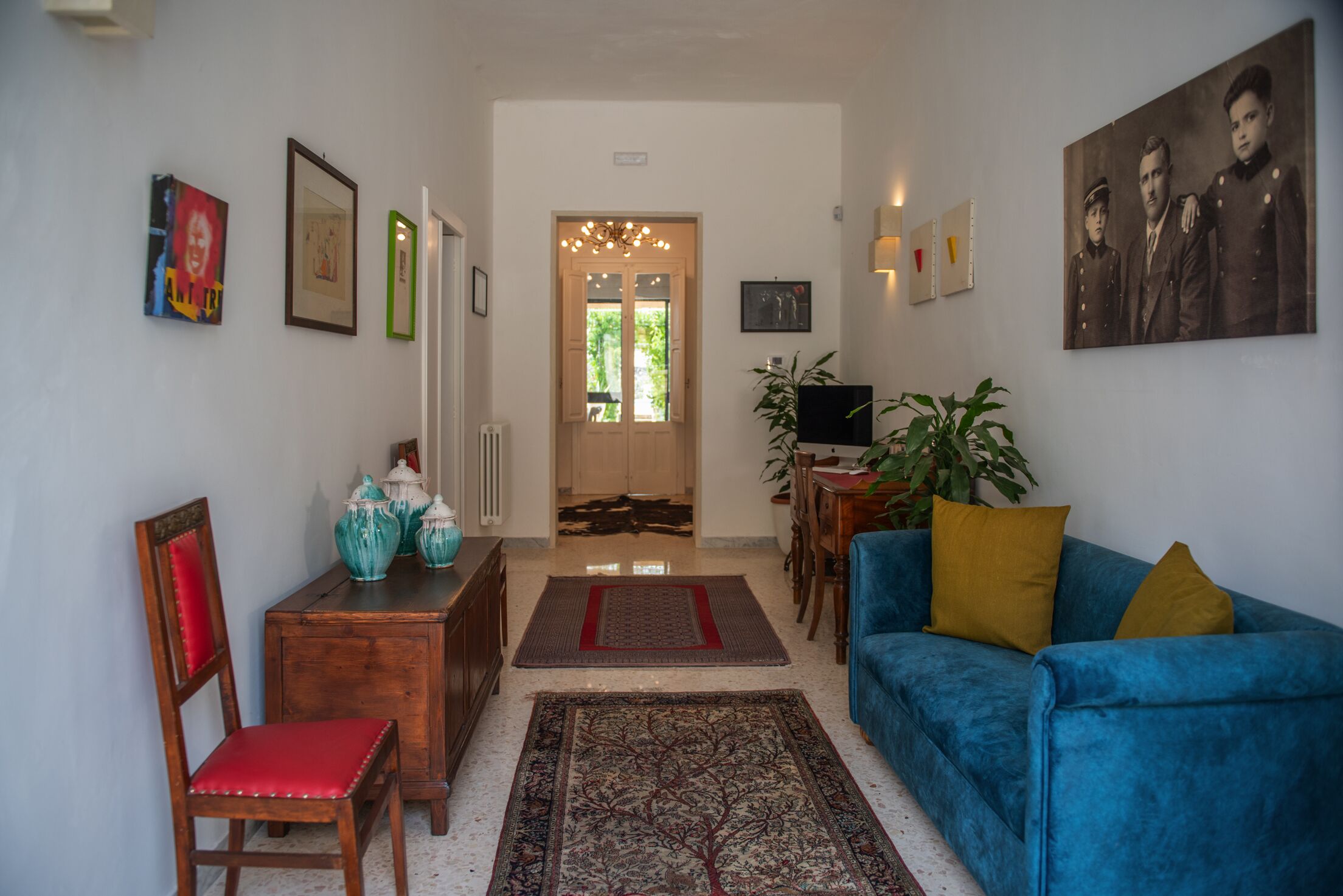 Ein Wohnzimmer mit einem blauen Sofa, einem Holzstuhl, einem Couchtisch und einem Fernseher.