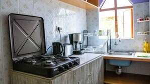 A kitchen with a gas stove, coffee maker, and a sink. - Charming 1-bed Penthouse in Karen Nairobi (Nairobi)