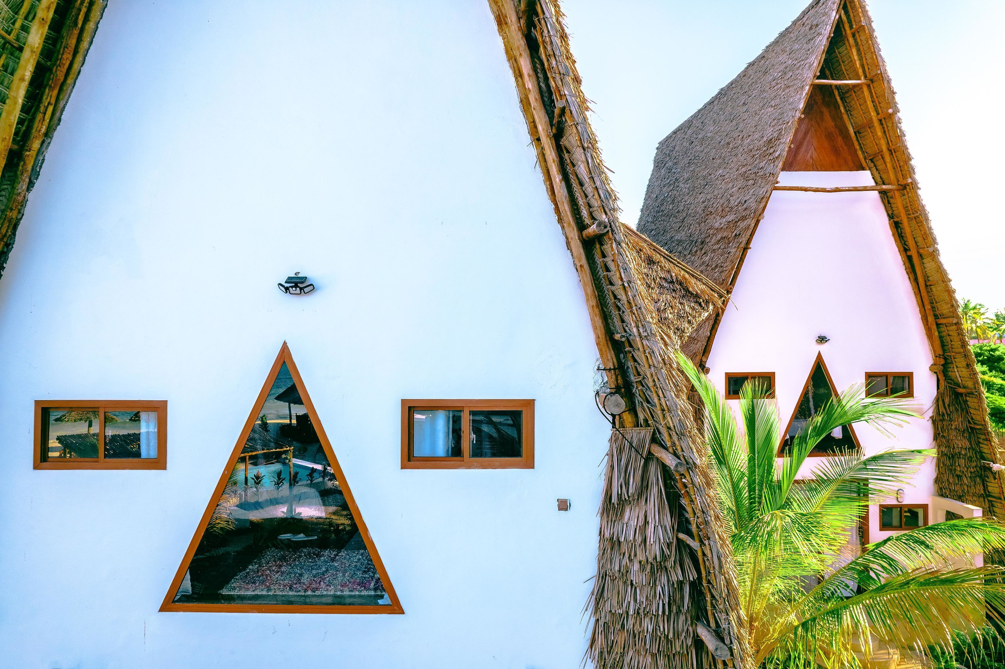 A building with triangular windows and a thatched roof.