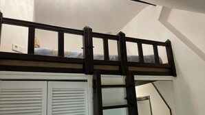 A bunk bed with a ladder, white walls, and a closet with louvered doors. - Studio Mezzanine 4 Personnes (Hargeville)