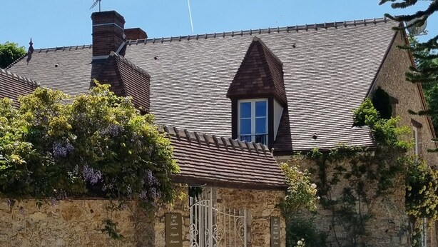 A stone building with a gravel driveway and a metal gate. - Studio Mezzanine 4 Personnes (Hargeville)