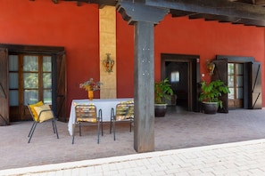 An outdoor seating area with a table and chairs, potted plants, and a wooden pergola structure. - Summer Dream by Fidalsa (Catral)