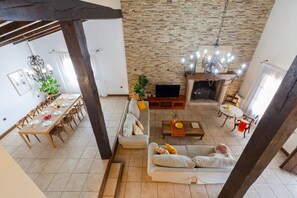 Un amplio espacio de estar con chimenea, comedor y una zona de asientos.