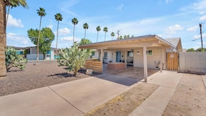 A modern house with a covered patio, palm trees, and a cactus in the yard. - Remodeled Gem w/ bocceball - 8 Minutes to Oldtown (Scottsdale)
