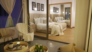 Un dormitorio moderno con una cama grande, una silla colgante y una mesita de noche con adornos.