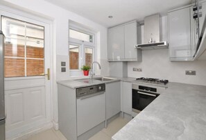 Enjoy cooking in this well-lit kitchen with a dishwasher, gas stove, and modern sink.