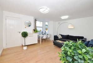 Relax in a comfortable living space with a sofa, potted plant, and modern decor.