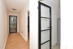 Enter a cozy space with a white door featuring a black frame and frosted glass panels.