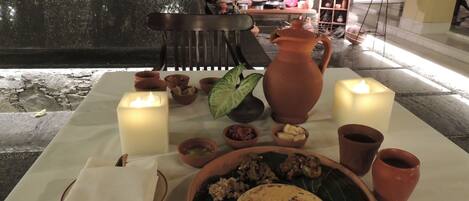 Una mesa dispuesta con un plato de comida, velas y una jarra.