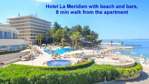 Un complexe hôtelier doté d’une piscine, d’une plage et d’un bâtiment comportant de nombreux balcons.