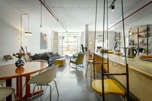 A modern kitchen with a bar area, wooden furniture, and a view to the outside. - Unique and Spacious 2BR Apt with Terrace (Tel Aviv)