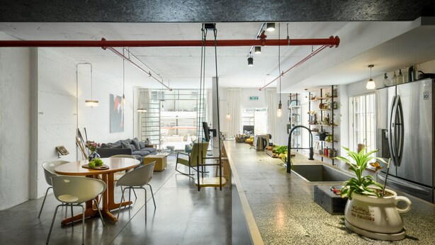 Una cocina moderna con una isla central, electrodomésticos de acero inoxidable y diversas plantas.