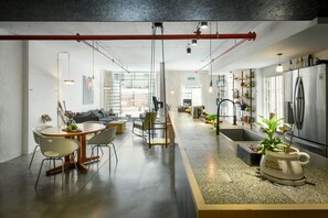 A modern kitchen with a central island, stainless steel appliances, and a variety of plants. - Unique and Spacious 2BR Apt with Terrace (Tel Aviv)