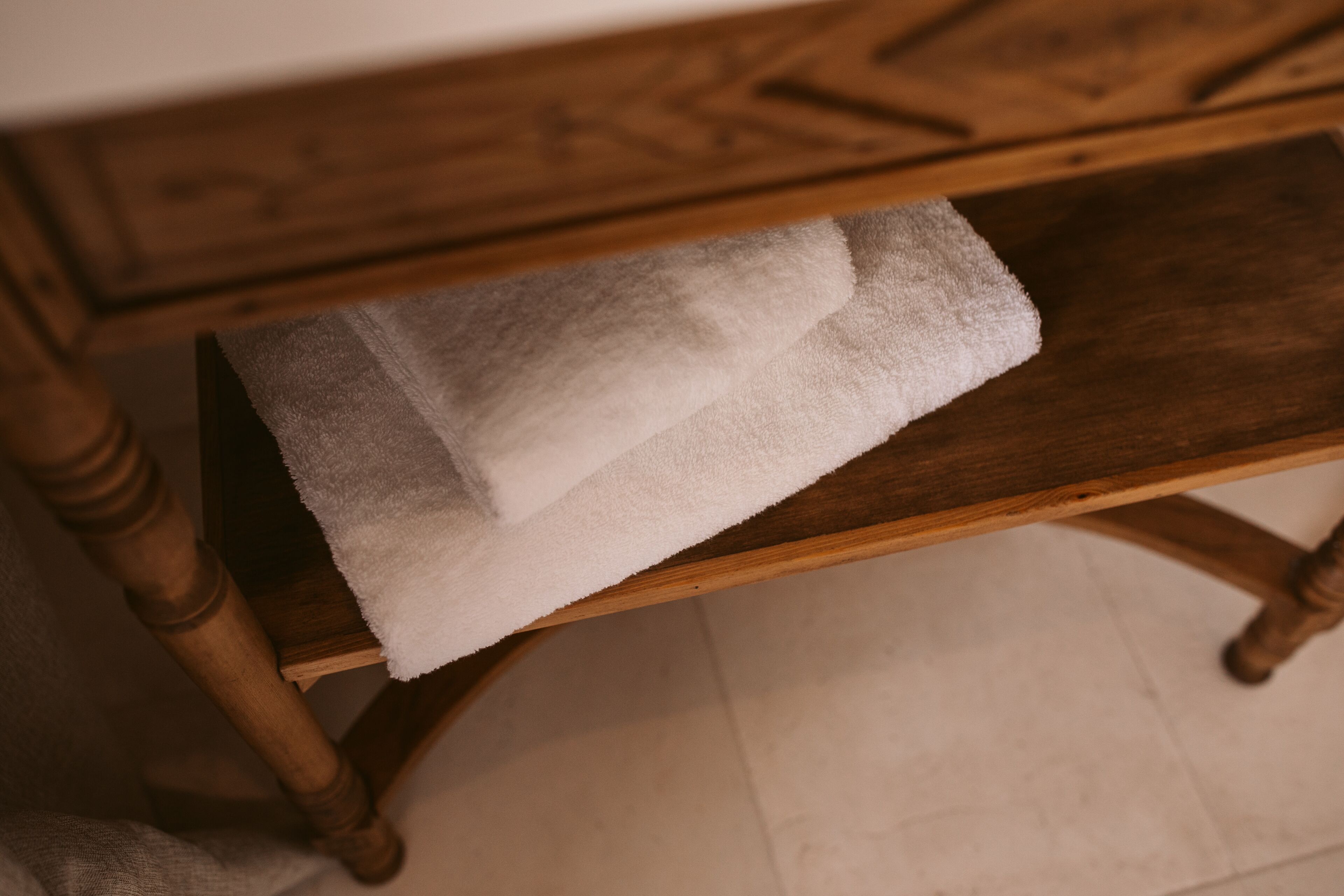 A wooden table with a white towel draped over it.