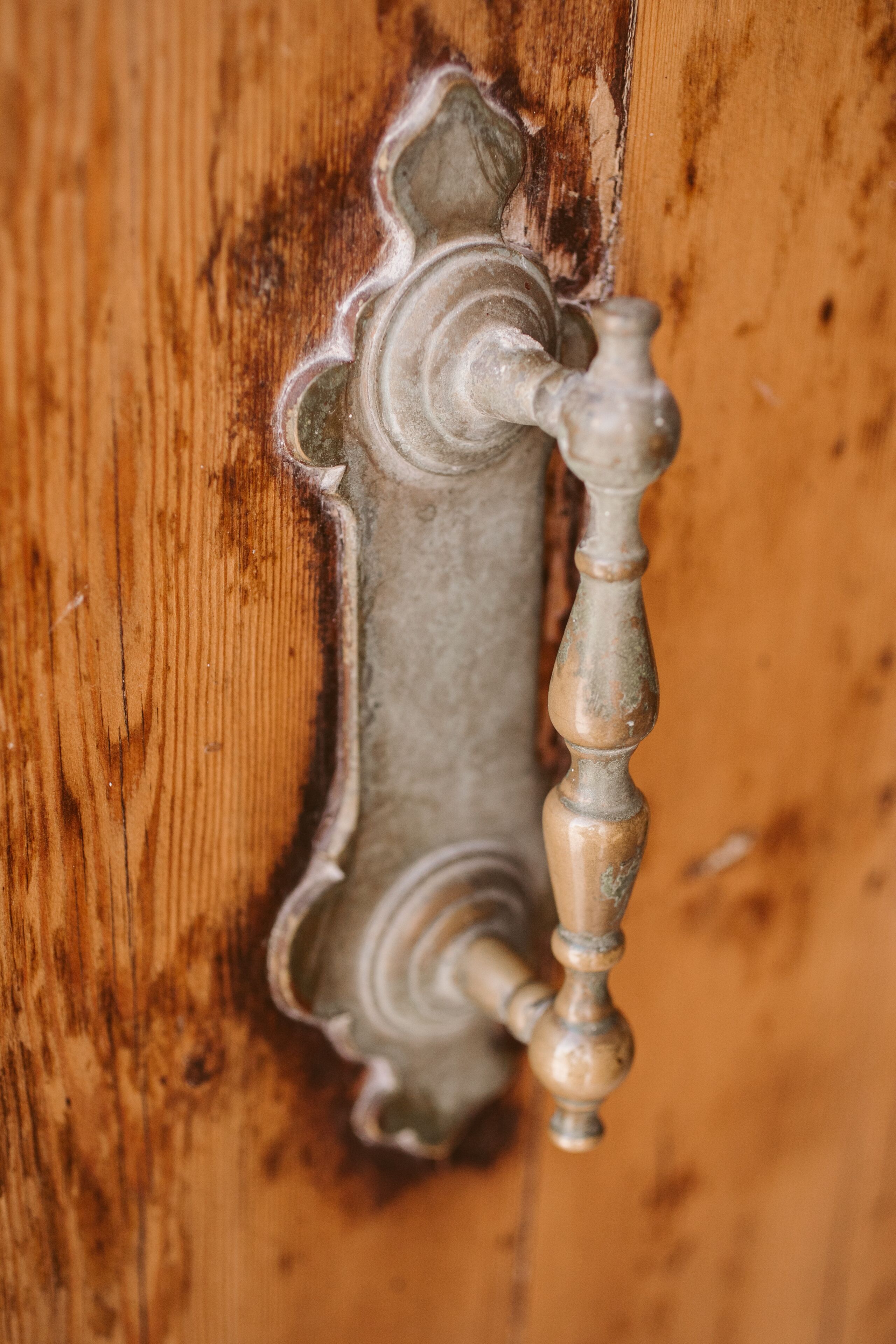 A close-up of a wooden door with a metal handle.