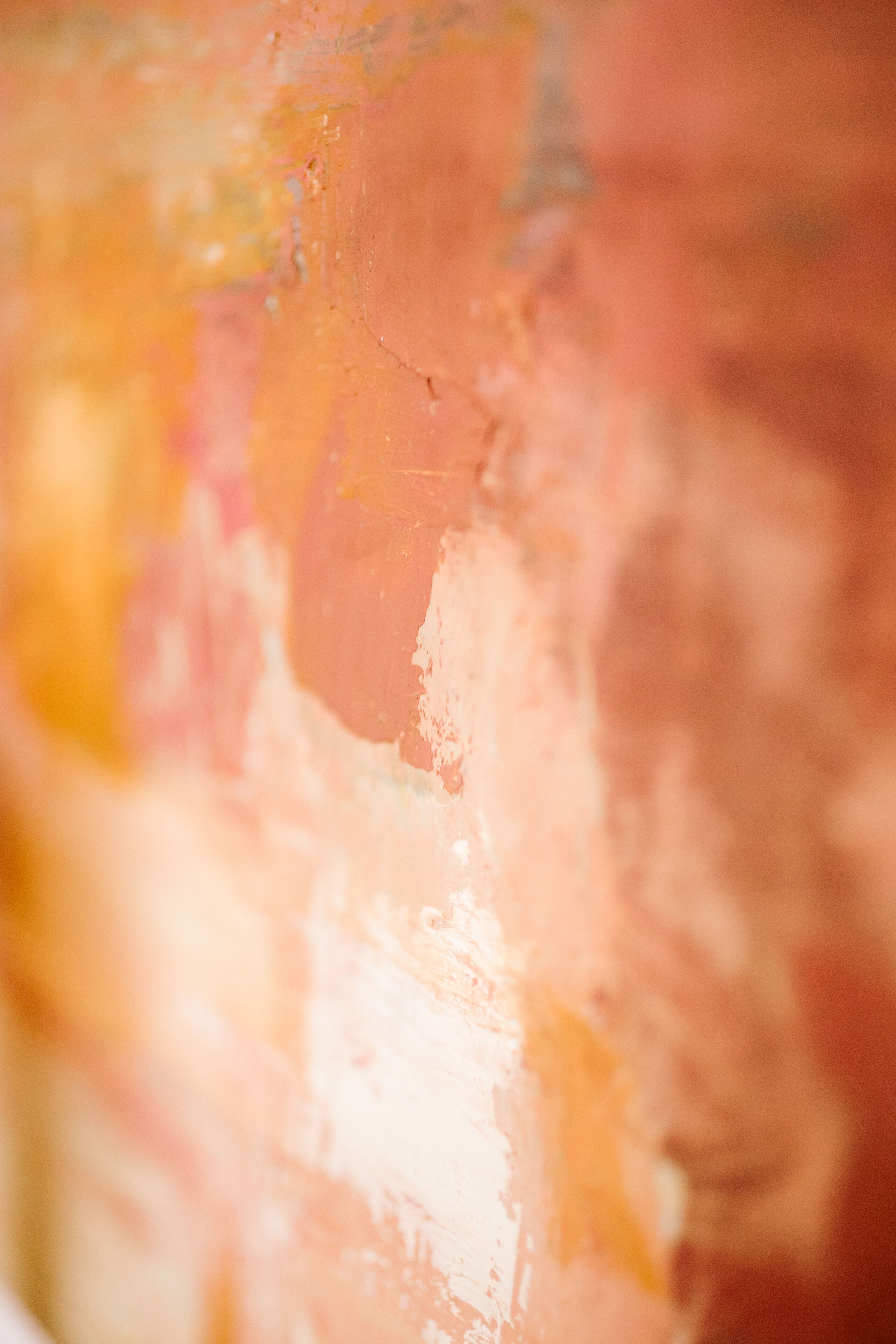 Detalle de una superficie texturizada con tonos anaranjados y rosados.