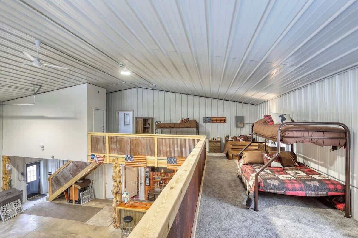 A spacious room with bunk beds, a wooden staircase, and a rustic decor.
