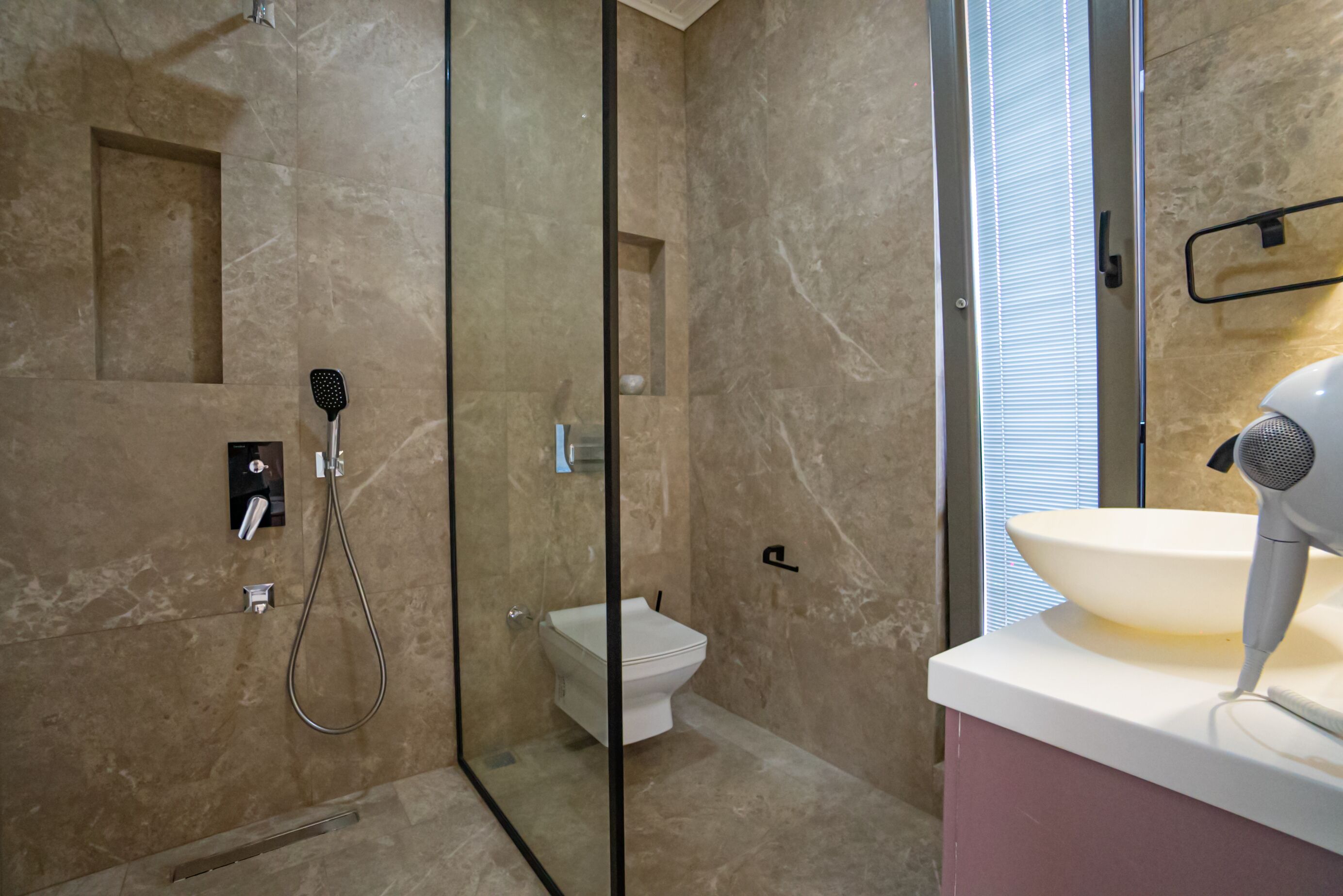 Un baño moderno con ducha envuelta en vidrio, inodoro y lavamanos.