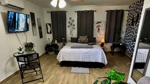A bedroom with a bed, a desk, a chair, a TV, and a ceiling fan. - Unidad 1 - Casa Cuatro Palmas 🌴 (rincon)