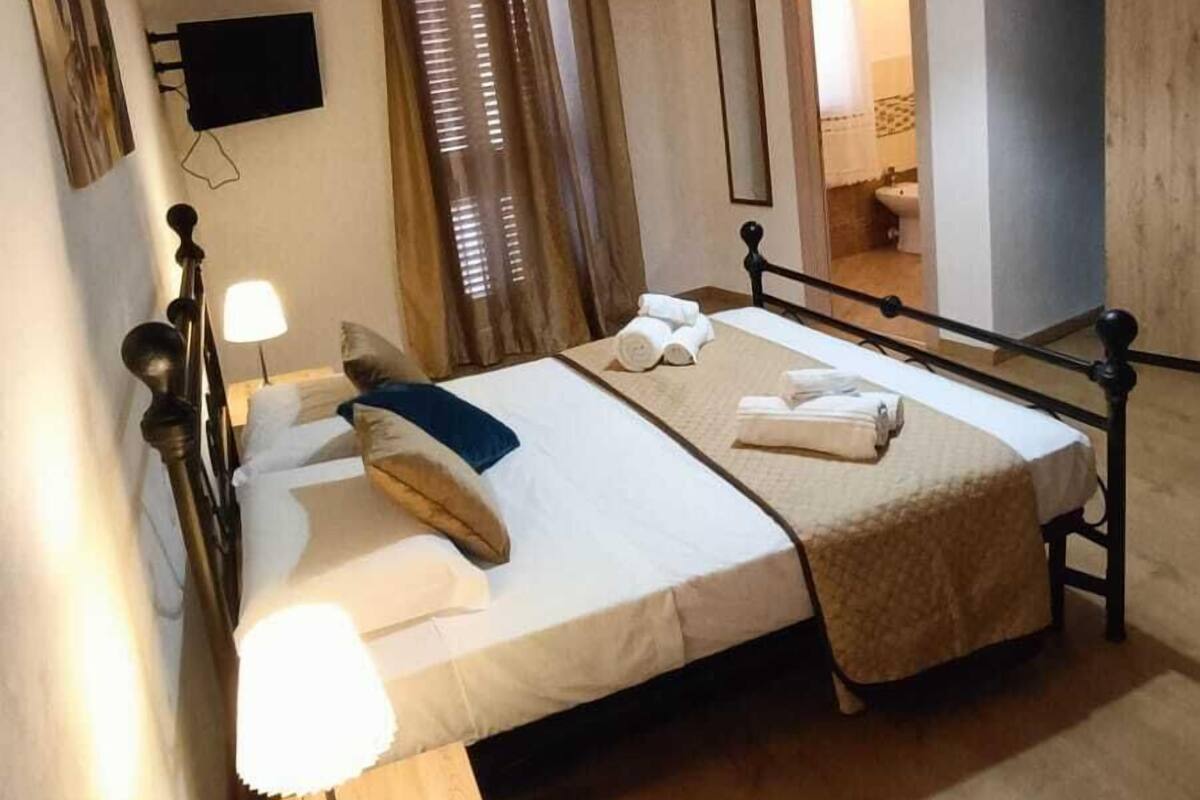 Ein Schlafzimmer mit einem Bett, Nachttischen, einer Lampe, einem Spiegel und einer Klimaanlage.