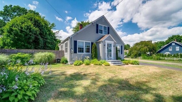 A single-story house with a gabled roof, a front porch, and a well-maintained lawn.
