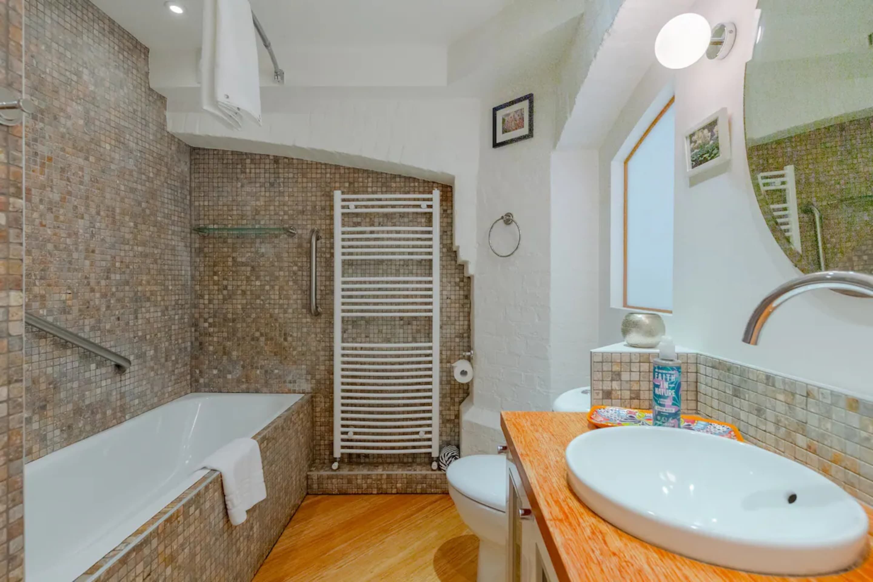 Een badkamer met een bad, toilet en wastafel.