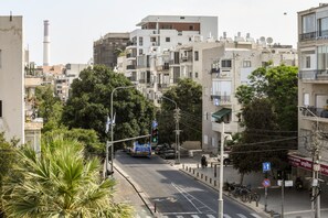 A street view with buildings, a traffic light, and a pedestrian crossing. - Spacious & Bright 3BR Apt with City View (Tel Aviv)