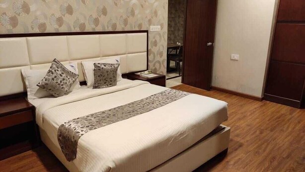 Ein Schlafzimmer mit einem großen Bett, zwei Nachttischen, einem Holzboden und einer Wand mit Muster.