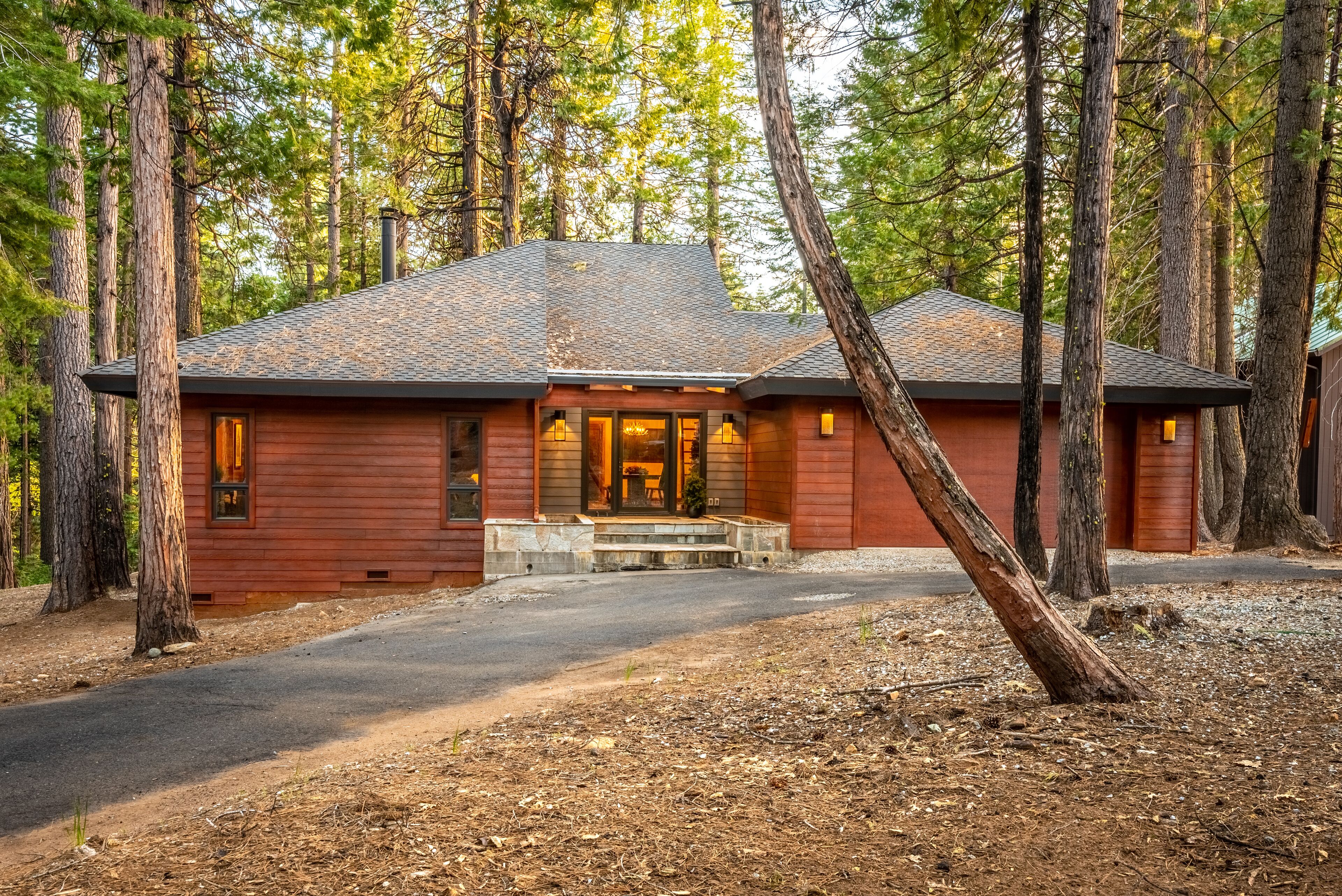 A cabin with a stone foundation, wooden exterior, and a chimney.