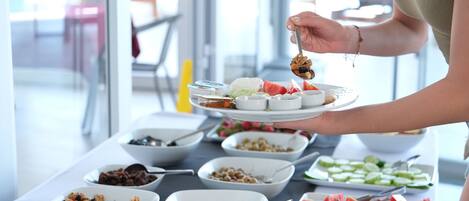 A buffet with various food items including fruits, vegetables, and dips.