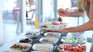 Un bufé con diferentes opciones de comida, incluyendo frutas, verduras y salsas.