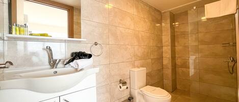 A modern bathroom with a sink, toilet, and shower.