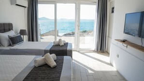A hotel room with two beds, a TV, and a view of the sea. - Ni Marin Hotel (Milas)