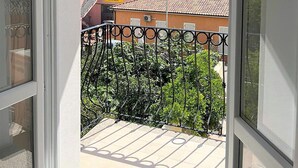 A balcony with a metal railing overlooking a residential area with houses and a clear sky. - Affittimoderni La Maddalena - MADA28 (La Maddalena)