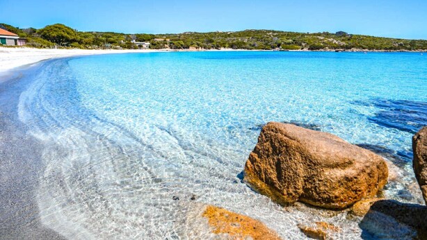 A clear beach with visible rocks and a distant shoreline. - Affittimoderni La Maddalena - MADA28 (La Maddalena)